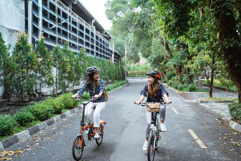 Vrouwen genieten van camper verhuur tijdens fietstocht. Electrische vouwfietsen aanvullend te huur via JustCamper.