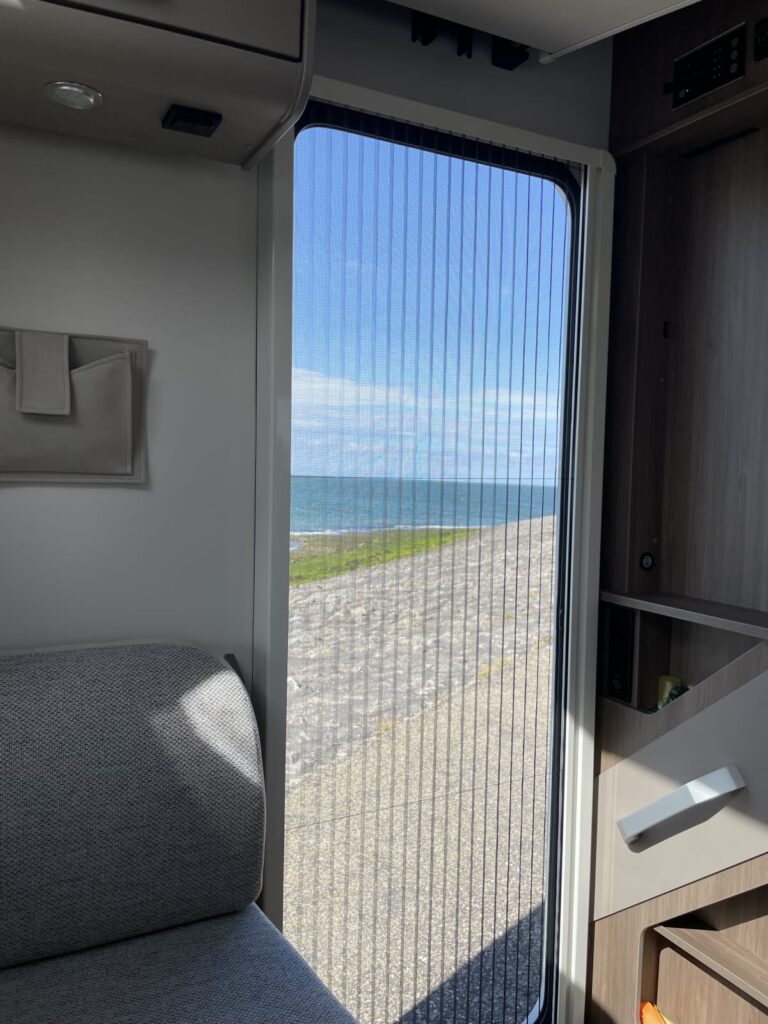 Carado T328 Pro+ Fiat Automaat JustCamper verhuur uitzicht door deur brouwersdam